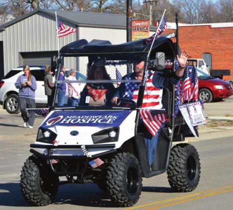 Rick and Lori Stanley drive a patriotic ATV through the parade for Meadowlark Hospice.