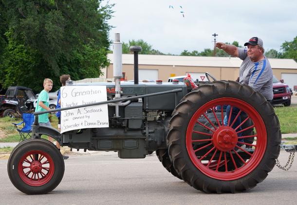 Darren Bruna throws candy from a 6th generation tractor on Saturday.