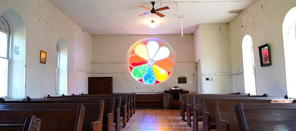 The 8-foot circular window glows with color inside the historic Baptist church in Steele City, Neb. The Jefferson County Historical Society used special artisans to restore the window.