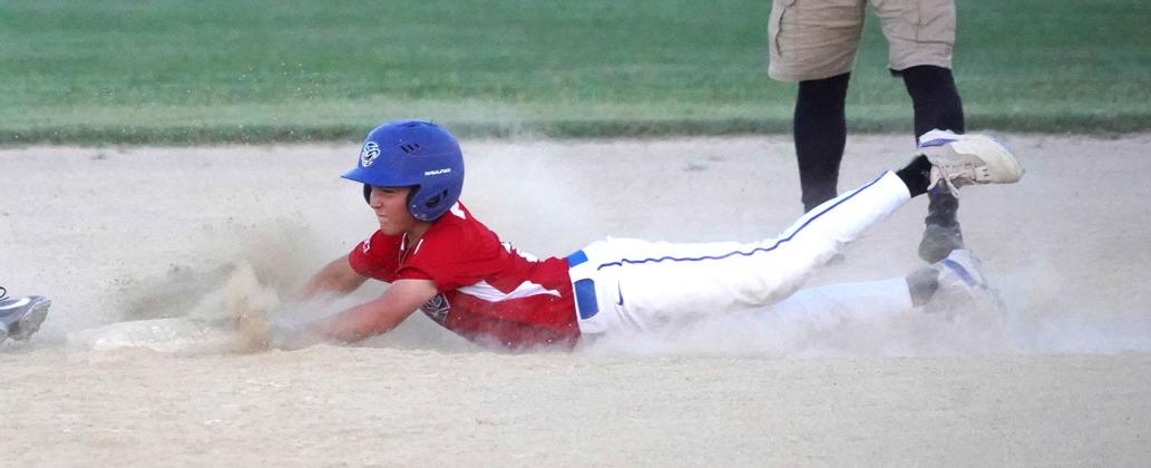 With a cloud of dust building, Colby Doebele slides hands-first into second base and is called safe in the district title game.