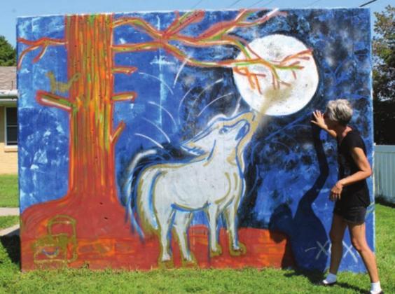 A wolf howls at the moon in one of Amy Kern’s panels. Each panel was a side of a tornado shelter. She painted 20 in all.