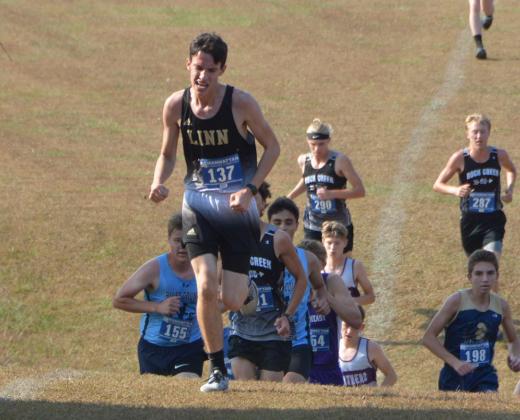 Linn senior Isaac Rogge charges up a hill in front of a large group of runners at Saturday’s Riley County Invitational.